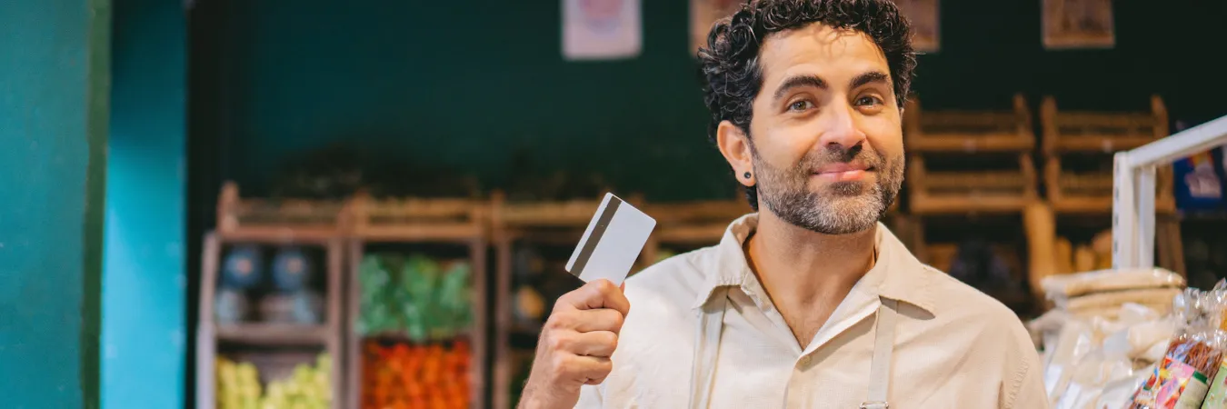 Business owner holding up his credit card